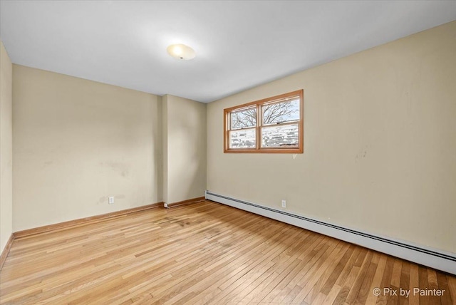 spare room featuring hardwood / wood-style flooring and a baseboard radiator