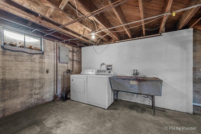 basement featuring electric panel, a sink, and independent washer and dryer