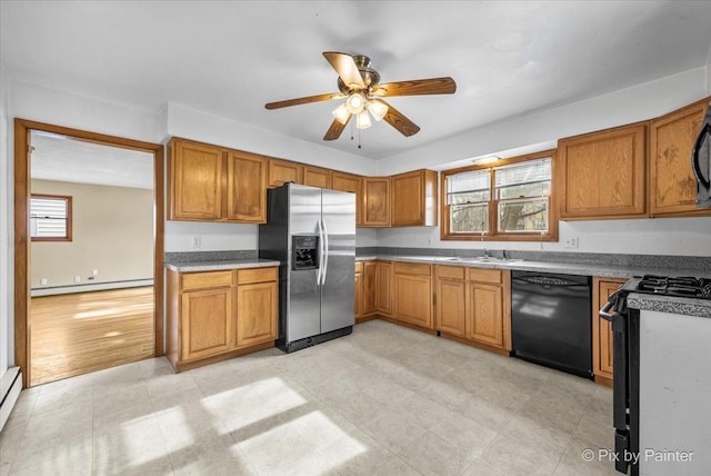 kitchen featuring black appliances, a baseboard radiator, brown cabinets, and a sink