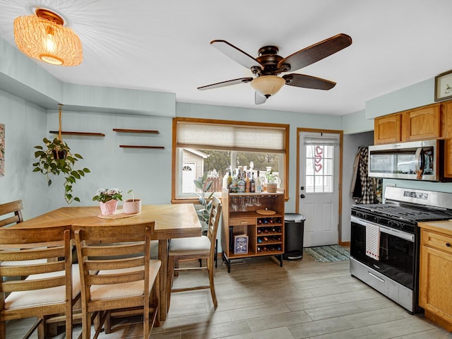 kitchen with stainless steel appliances, ceiling fan, and light hardwood / wood-style floors