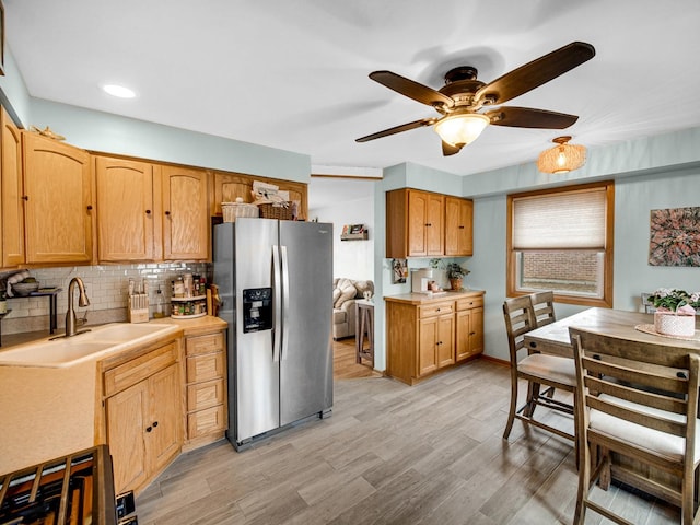 kitchen featuring decorative backsplash, stainless steel fridge, sink, and light hardwood / wood-style flooring