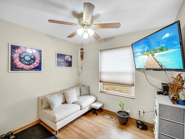 living area featuring hardwood / wood-style floors and ceiling fan