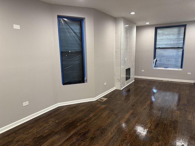 unfurnished living room featuring hardwood / wood-style flooring and a high end fireplace