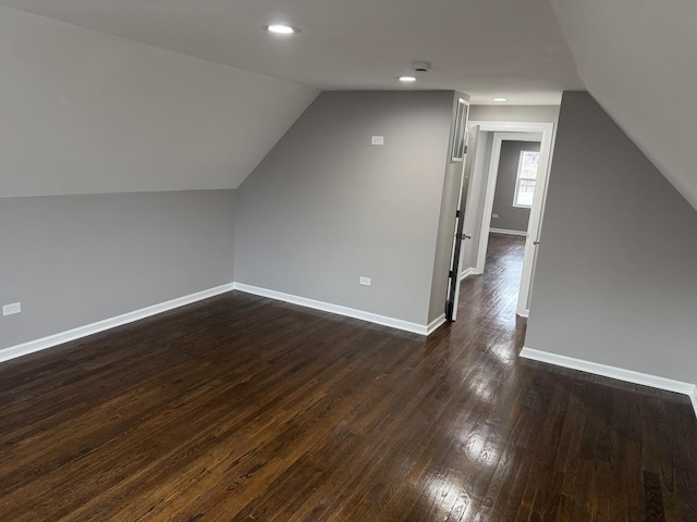 additional living space featuring lofted ceiling and dark wood-type flooring