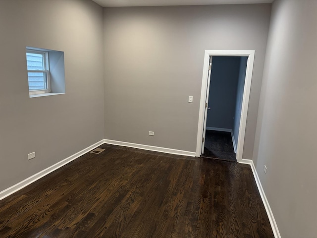 spare room with dark wood-type flooring