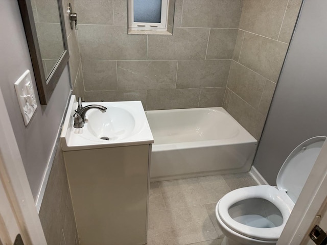 full bathroom with tile patterned flooring, vanity, tiled shower / bath combo, and toilet