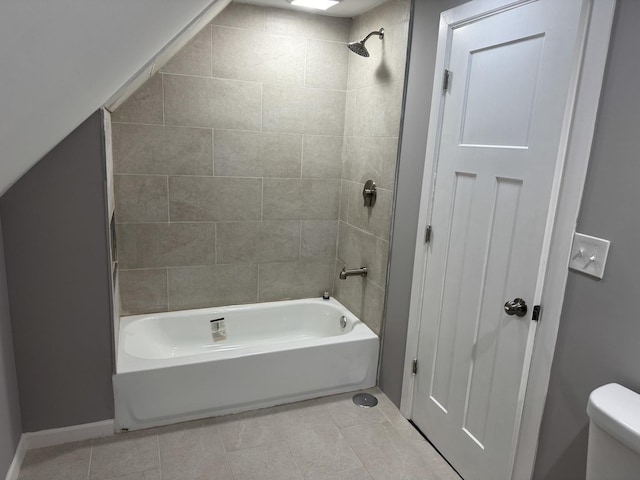 bathroom featuring tiled shower / bath combo, tile patterned floors, and toilet