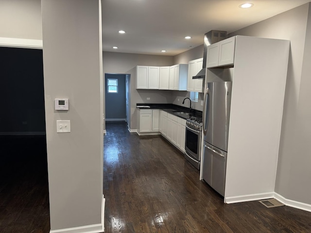 kitchen featuring stainless steel appliances, white cabinetry, sink, and dark hardwood / wood-style floors