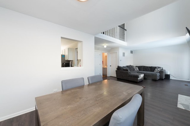 dining room featuring dark hardwood / wood-style floors and a high ceiling