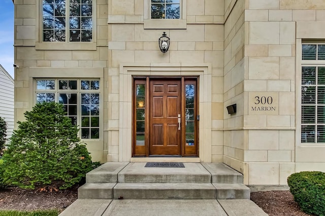 view of exterior entry featuring beverage cooler and stone siding