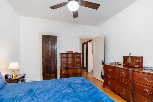 bedroom featuring crown molding, light hardwood / wood-style floors, and ceiling fan