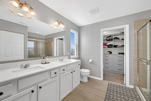 full bath with double vanity, a stall shower, visible vents, and a sink