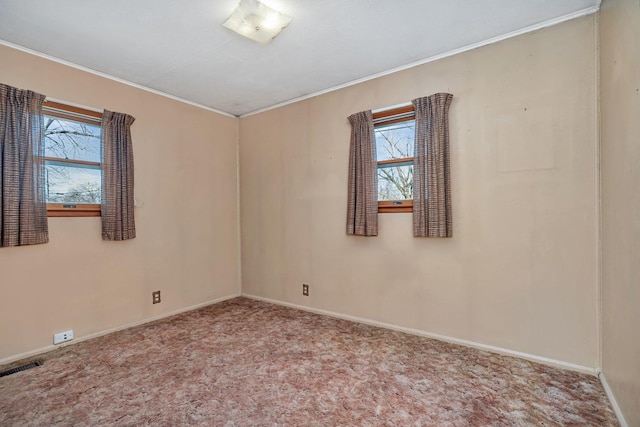 carpeted spare room featuring crown molding