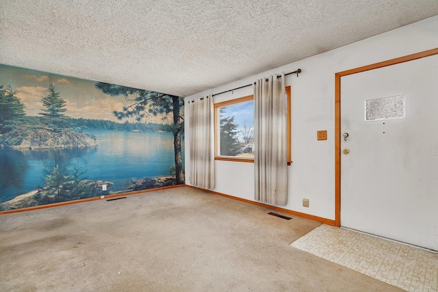 entrance foyer with a textured ceiling and carpet