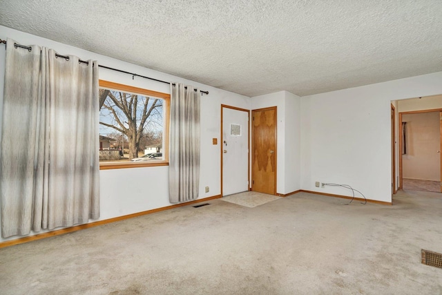 unfurnished room featuring light carpet and a textured ceiling