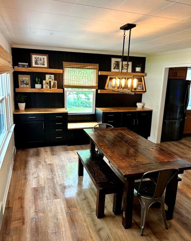 dining space with crown molding and light wood-type flooring