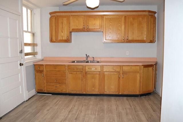 kitchen with ceiling fan, sink, and light hardwood / wood-style floors