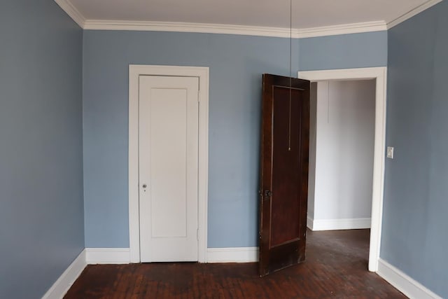 unfurnished bedroom featuring ornamental molding and dark hardwood / wood-style floors