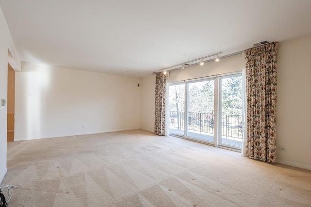 carpeted spare room with rail lighting