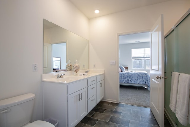 bathroom with walk in shower, vanity, and toilet