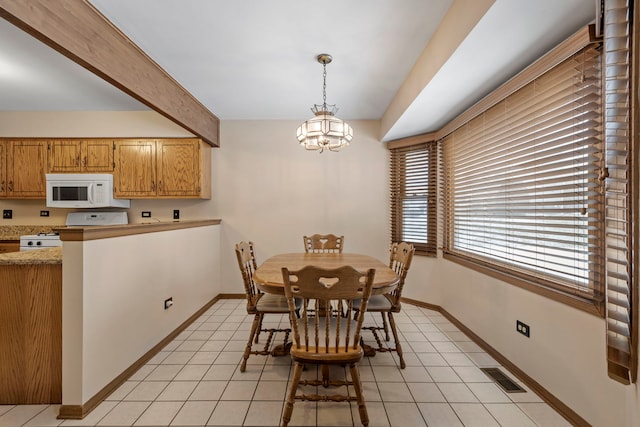 tiled dining space with a chandelier