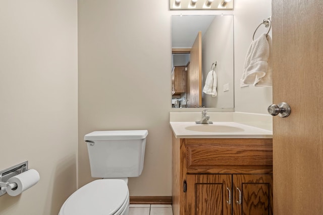 bathroom with tile patterned flooring, vanity, and toilet