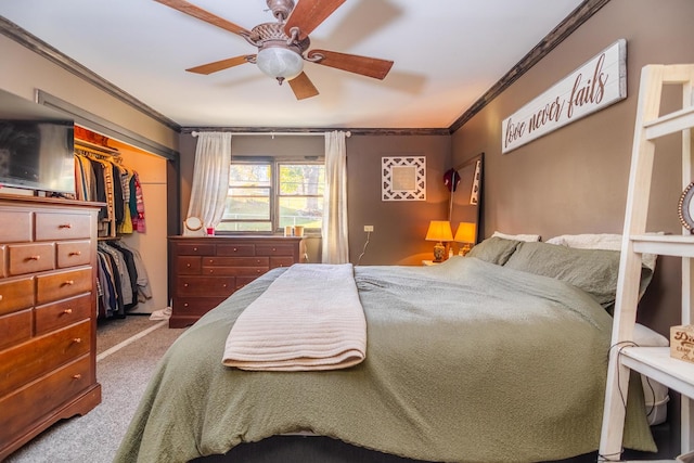 bedroom with ceiling fan, ornamental molding, carpet flooring, and a closet