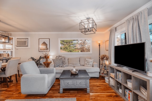 living room featuring ornamental molding, wood-type flooring, and a notable chandelier