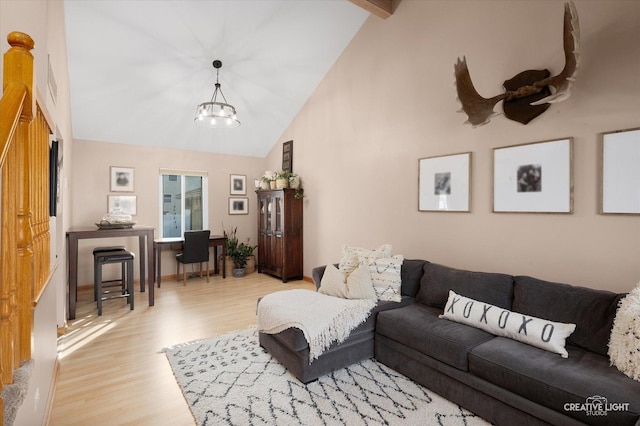 living room featuring beamed ceiling, a chandelier, high vaulted ceiling, and light hardwood / wood-style flooring