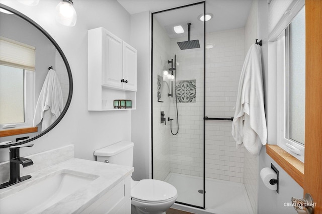 bathroom with toilet, vanity, and a shower with shower door