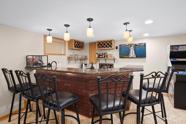 bar featuring pendant lighting and dark stone countertops