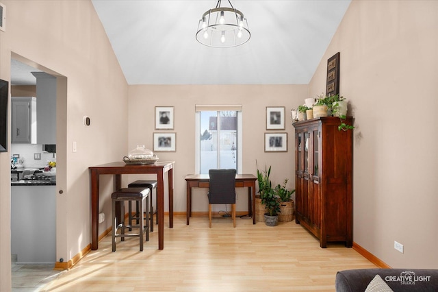 interior space featuring lofted ceiling, pendant lighting, an inviting chandelier, and light wood-type flooring