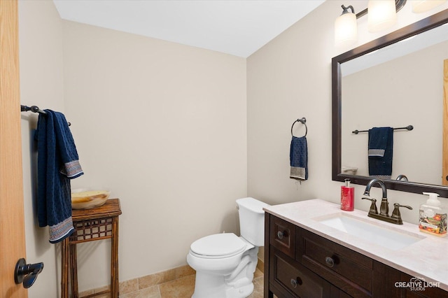 bathroom featuring vanity, tile patterned flooring, and toilet