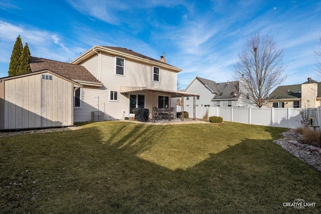 rear view of property with a patio, a yard, and a storage unit