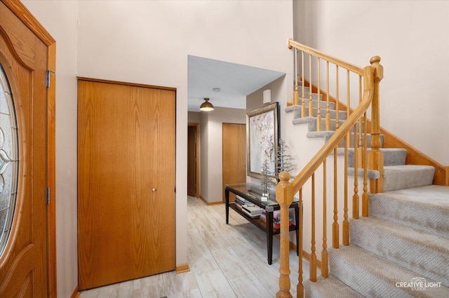 stairway with a towering ceiling and wood-type flooring