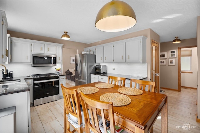 kitchen featuring tasteful backsplash, sink, stainless steel appliances, and white cabinets