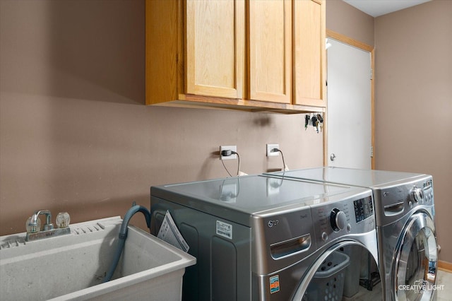 laundry area featuring cabinets, washer and dryer, and sink