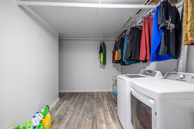 washroom with hardwood / wood-style flooring and washing machine and clothes dryer