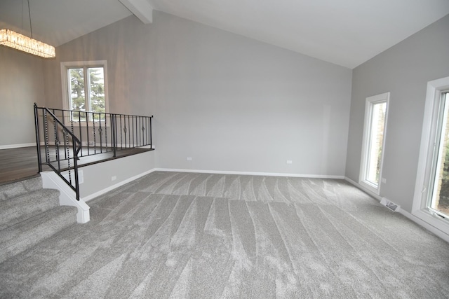 spare room featuring high vaulted ceiling, baseboards, stairs, beam ceiling, and carpet