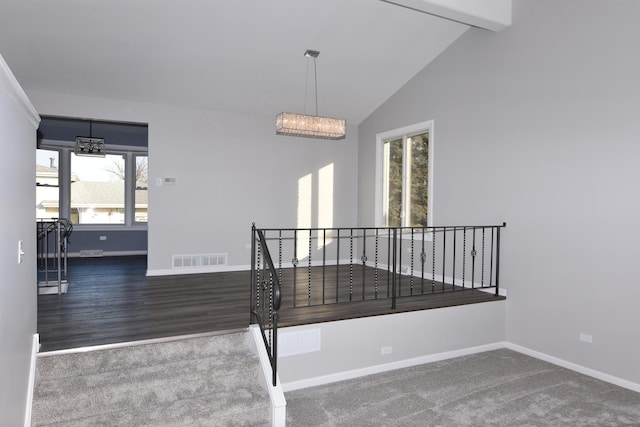 interior space featuring visible vents, baseboards, dark colored carpet, beamed ceiling, and an inviting chandelier