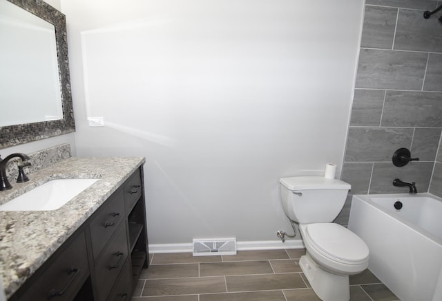 bathroom with toilet, visible vents, vanity, baseboards, and washtub / shower combination