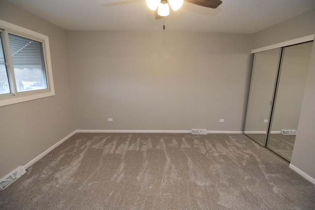 unfurnished bedroom featuring a ceiling fan, visible vents, baseboards, a closet, and carpet