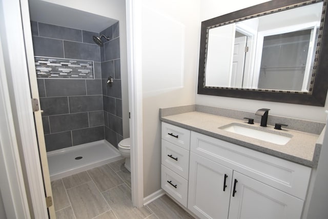 full bathroom with a stall shower, vanity, and toilet