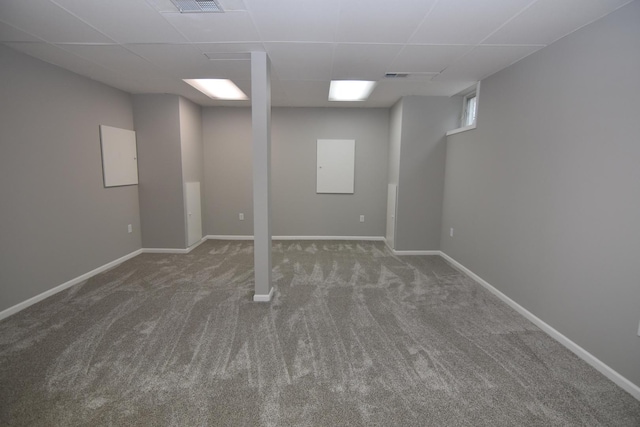 finished basement with a drop ceiling, carpet flooring, visible vents, and baseboards