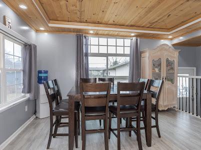 dining room featuring wood ceiling, a raised ceiling, and light wood-type flooring