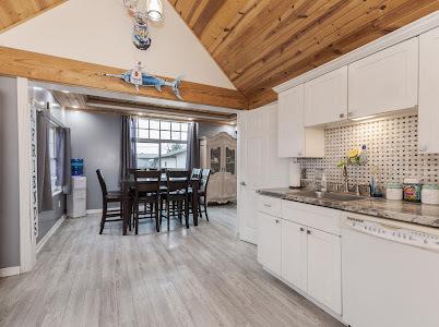 kitchen featuring sink, white dishwasher, tasteful backsplash, light hardwood / wood-style floors, and white cabinets