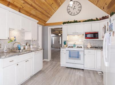 kitchen featuring white cabinetry, sink, white appliances, wooden ceiling, and light wood-type flooring