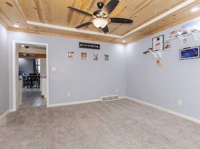 unfurnished room featuring wood ceiling, a raised ceiling, ceiling fan, and carpet