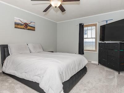 carpeted bedroom featuring crown molding and ceiling fan