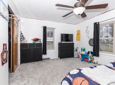 bedroom with ceiling fan and light carpet